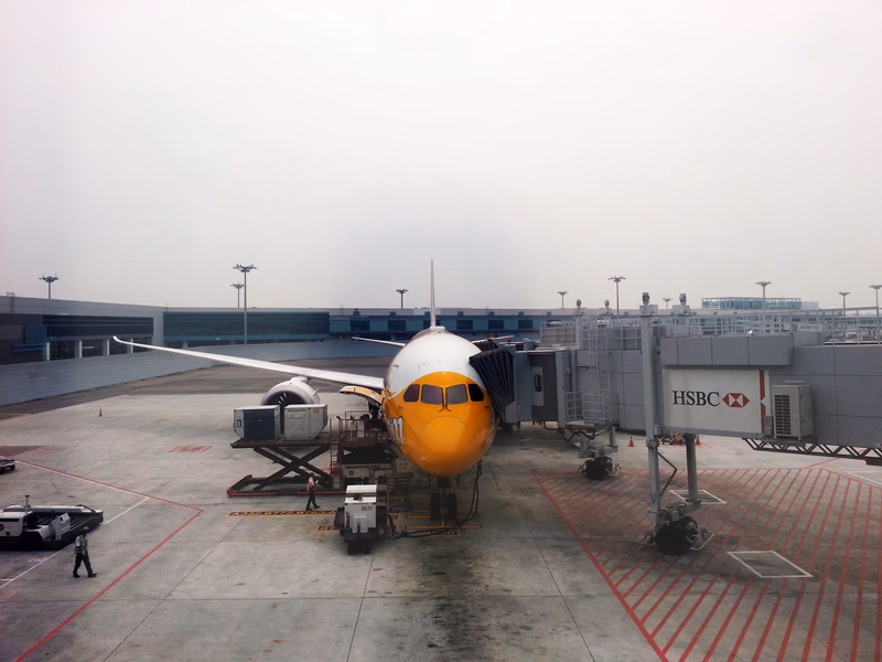 A photo of an airplane at an airport gate with a jet bridge connected to it.